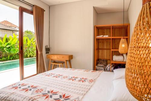 a bedroom with a bed with a swing at Rumah Melissa - Modern Boho 3BR Brand New Villa in Sanur in Sanur
