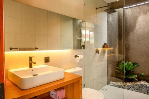 a bathroom with a sink and a toilet and a shower at Rumah Melissa - Modern Boho 3BR Brand New Villa in Sanur in Sanur