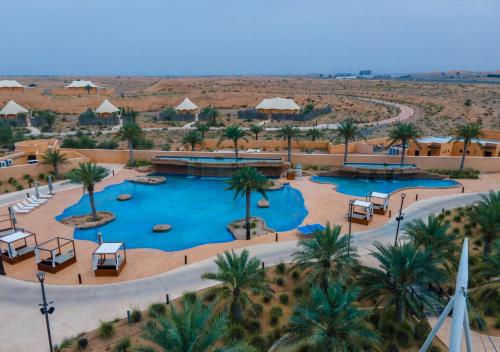 an aerial view of a resort with two pools and palm trees at Al Badayer Retreat by Sharjah Collection in Sharjah