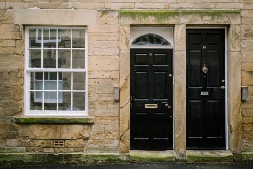 two black doors on a stone building with windows at Sun Street Retreats in Lancaster