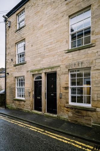 a wooden building with two doors on a street at Sun Street Retreats in Lancaster