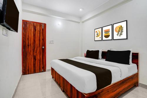 a bedroom with a large bed and a television at Hotel O rudra paradise in New Delhi