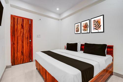 a bedroom with a large bed and a red door at Hotel O rudra paradise in New Delhi