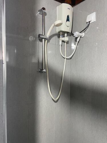 a shower with a hose attached to a wall at Ruchi House in Nuwara Eliya