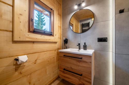 a bathroom with a sink and a mirror at Drewniane Zacisze in Biały Dunajec