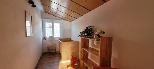 a room with a stairway with a shelf and a window at Ferienwohnung Stützen in Brig