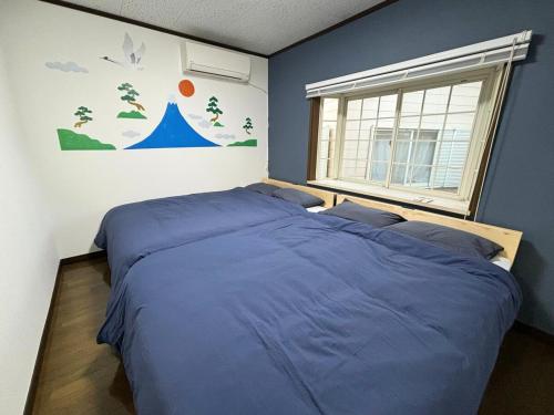 a bedroom with two beds and a window at Kawagoe Cinema & Game House for 14 Parking in Kawagoe
