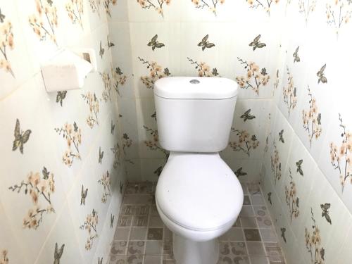 a bathroom with a toilet with butterflies on the wall at Kabera House 1 in Ubud