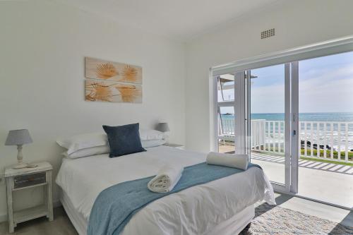 a bedroom with a bed with a view of the ocean at On the Rocks in Yzerfontein