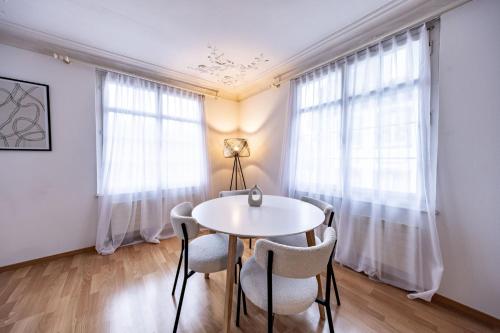 a dining room with a white table and chairs at The R Apartment Hemmental in Schaffhausen