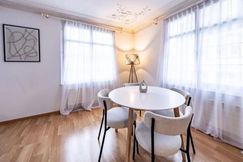a dining room with a white table and chairs at The R Apartment Hemmental in Schaffhausen