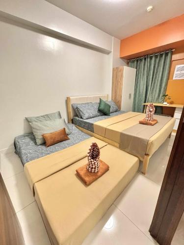 a room with two beds and a couch at NM 1BR Condo with Balcony at Horizons 101 in Cebu City