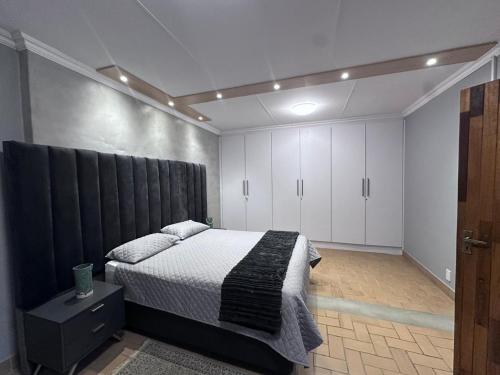 a bedroom with a bed with a black headboard at Forest and Ferns in Graskop