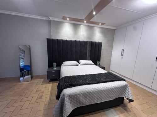 a bedroom with a large bed with a black headboard at Forest and Ferns in Graskop