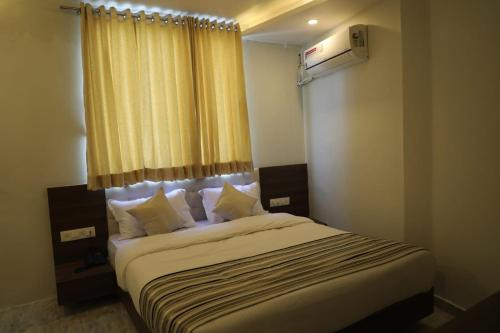 a bedroom with a large bed with a window at HOTEL RAJPATH Inn in Mahesāna