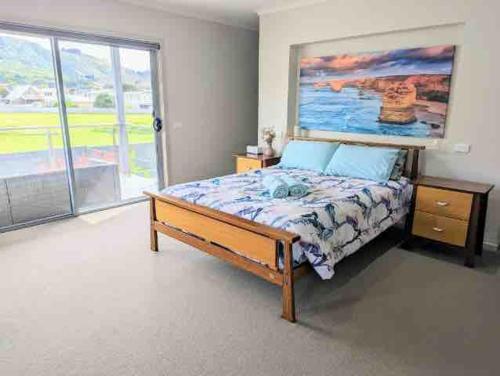a bedroom with a bed and a large window at Large Five Bdrm Home Near Beach in Apollo Bay