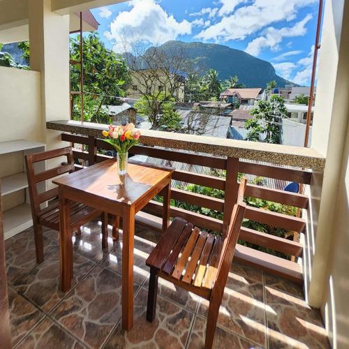 een tafel en stoelen op een balkon met uitzicht bij SILVERISE Pension in El Nido