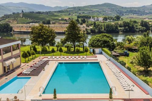 an overhead view of a swimming pool with a river in the background at Hotel Columbano in Peso da Régua