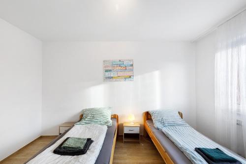 two twin beds in a room with white walls at Bruchköbel auch für Monteure in Bruchköbel