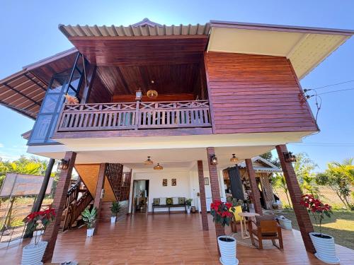 een huis met een terras en een balkon bij Chewavethee Herb Wellness Stay in Ban Chae Phang (1)
