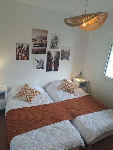 two beds in a bedroom with pictures on the wall at La maison d'à côté in Desingy