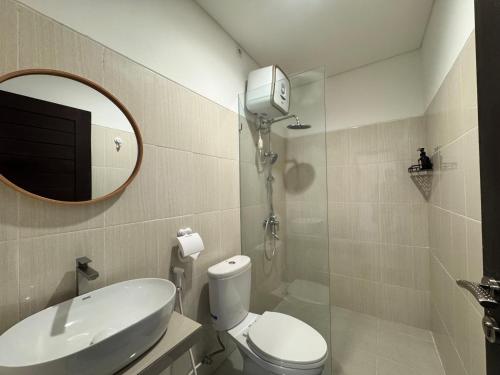 a bathroom with a toilet and a sink and a mirror at Chevana House Jimbaran in Jimbaran