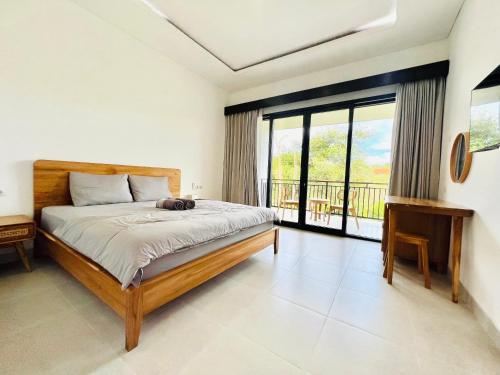 a bedroom with a bed and a balcony at Chevana House Jimbaran in Jimbaran