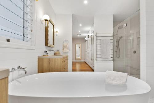 a large white bathroom with a tub and a shower at Coastal Luxe - Hampton inspired in Kingscliff