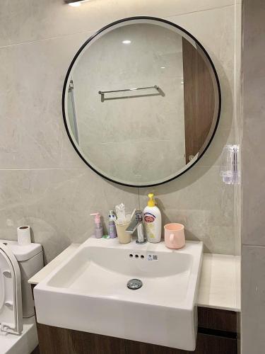 a bathroom sink with a large mirror above it at Capsule Masterise Vinhomes in Gia Lâm Pho