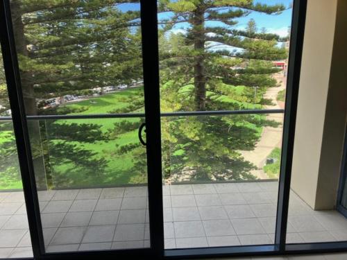 an open glass door with a view of a yard at The Heart of Glenelg in Glenelg