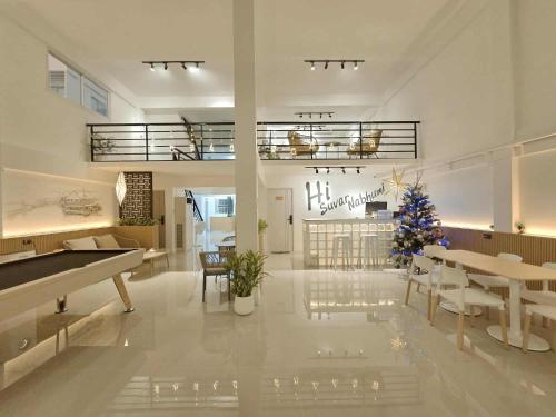 a living room with a piano and a christmas tree at Hi Suvarnabhumi in Ban Khlong Prawet