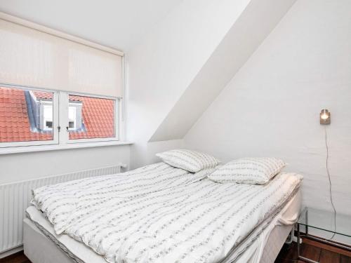 een witte slaapkamer met een bed en een raam bij 6 person holiday home in Skagen in Skagen