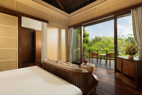 a bedroom with a bed and a large window at Villa Leona Ubud in Ubud