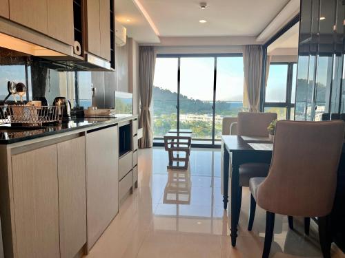 a kitchen with a table and a dining room at Surin Beach View Phuket in Ban Lum Fuang