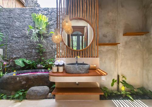 a bathroom with a sink and a mirror at Bara Villa by GenuineHost in Tegalalang