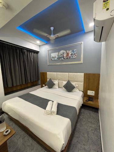 a bedroom with a large bed with a blue ceiling at Hotel secure inn kadodara road in Surat