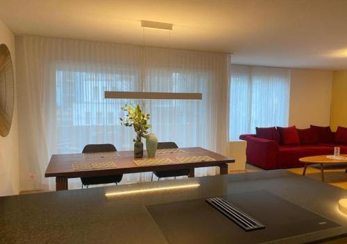 a living room with a table and a red couch at The R Apartment Adlisberg in Geroldswil