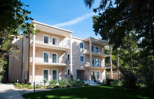 un gran edificio de apartamentos con árboles delante de él en Maistra Select Srebreno Villas, en Mlini