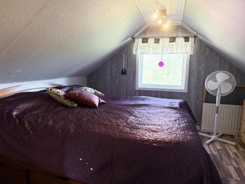 a bedroom with a large bed in a attic at Charming red cottage in Vaderstad SE10024 in Väderstad