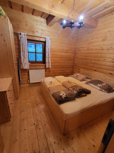 a bedroom with a bed in a log cabin at Chata pod Kykulou in Oščadnica
