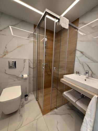 een badkamer met een douche, een toilet en een wastafel bij Compass Hotel in Albena