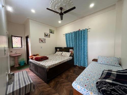 una camera da letto con due letti e un ventilatore a soffitto di Chandarshila hike homestay a Ukhimath