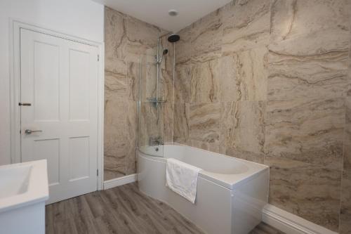 a bathroom with a bath tub and a sink at Dale View in Youlgreave