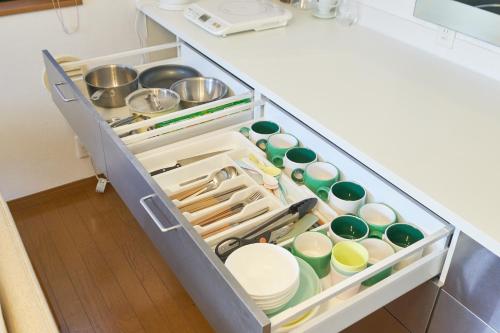 an open kitchen drawer filled with dishes and utensils at Yotsuya Lantern - Private 3 stories house for family in Tokyo