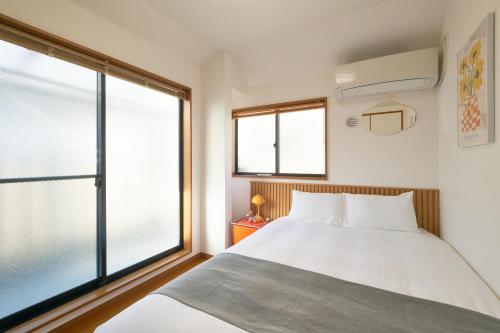 a bedroom with a bed and a large window at Yotsuya Lantern - Private 3 stories house for family in Tokyo