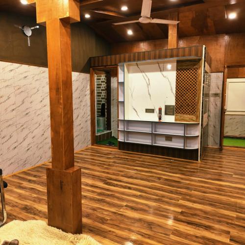 a room with wood floors and a large mirror at Id villa cottage in Tangmarg