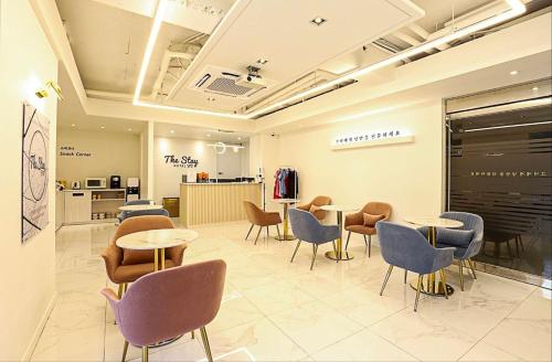 a waiting room with tables and chairs in a store at The Stay Nangman Seongseo in Daegu