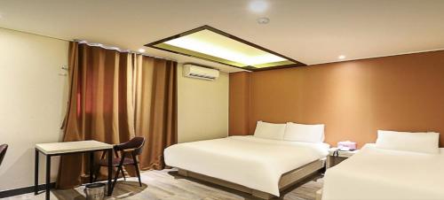 a hotel room with two beds and a window at The Stay Nangman Seongseo in Daegu