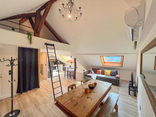 een woonkamer met een tafel en een bank bij Cocon sous les toits in Albertville