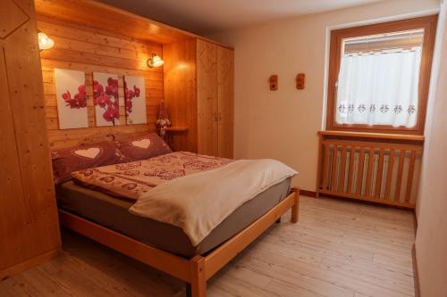 a bedroom with a bed in a room with a window at Appartamenti Chalet Canedi in Peio